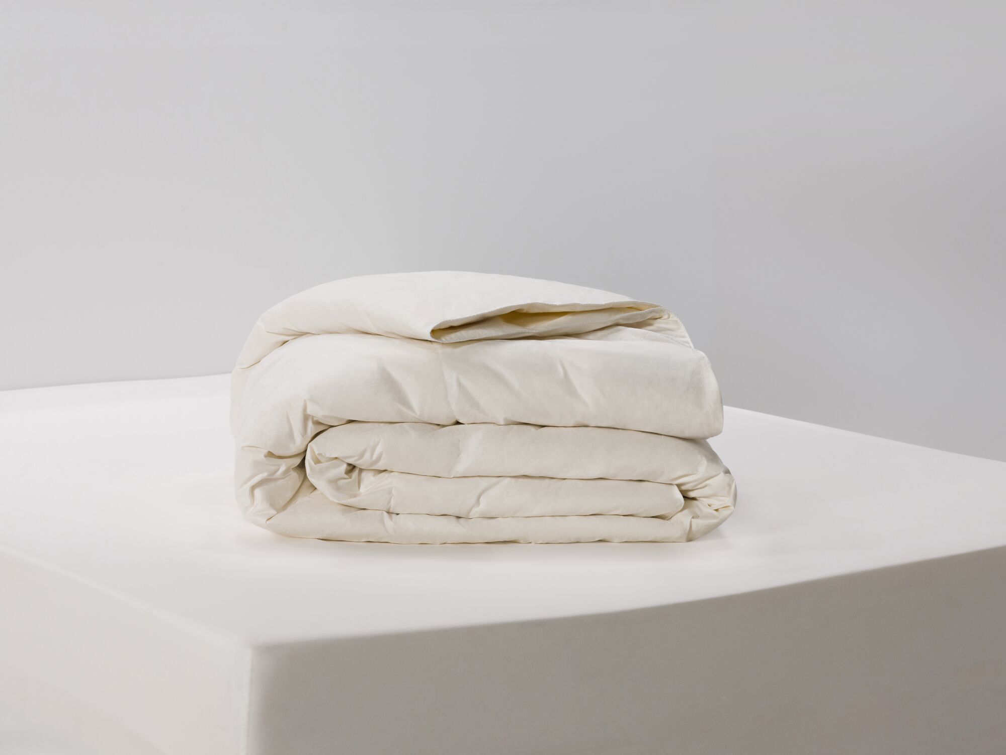 Side view of folded ivory down duvet